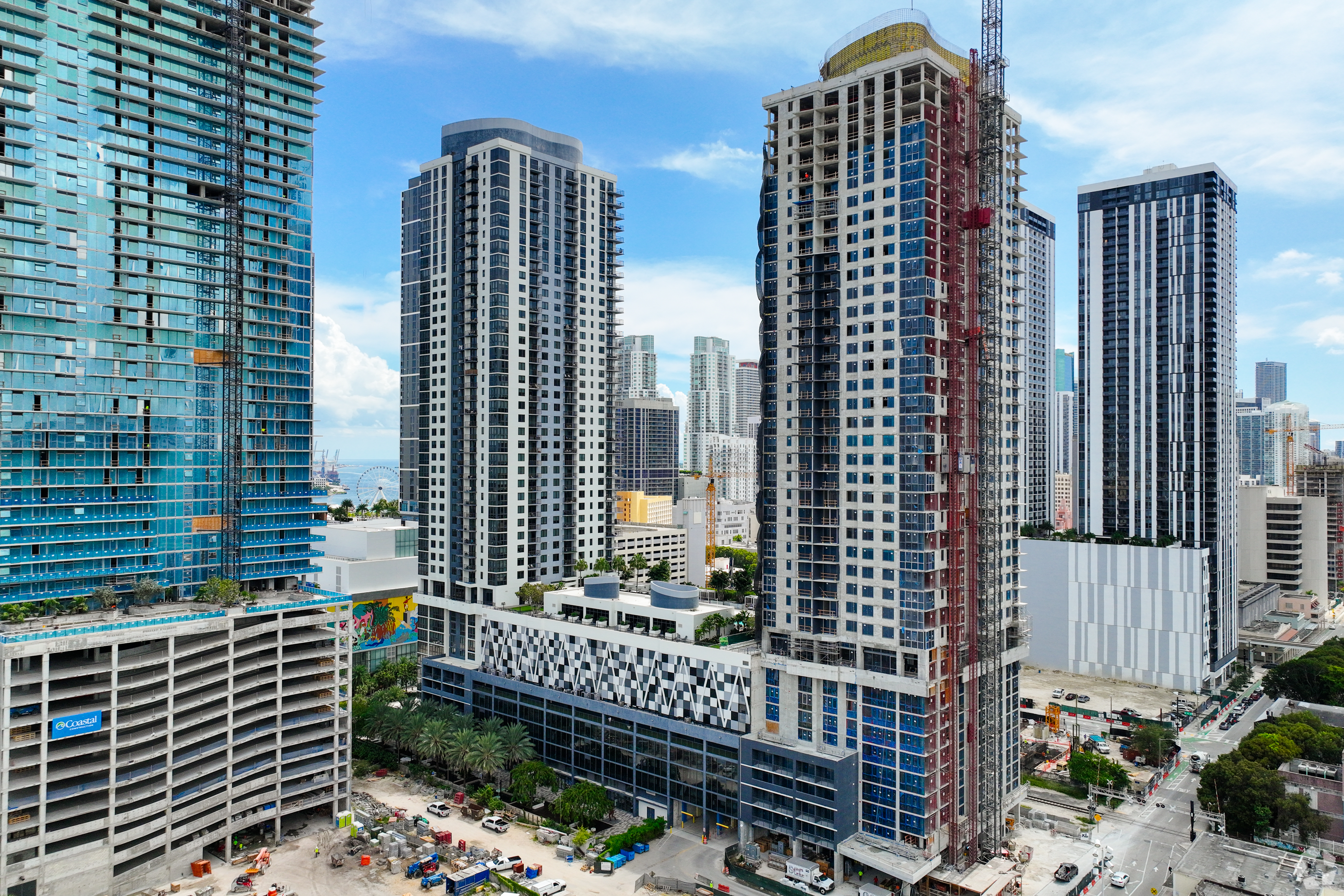Flow is building its first condominium project, Flow House, at right with the crane, connected to one of Flow's apartment properties, Flow Miami. (CoStar)