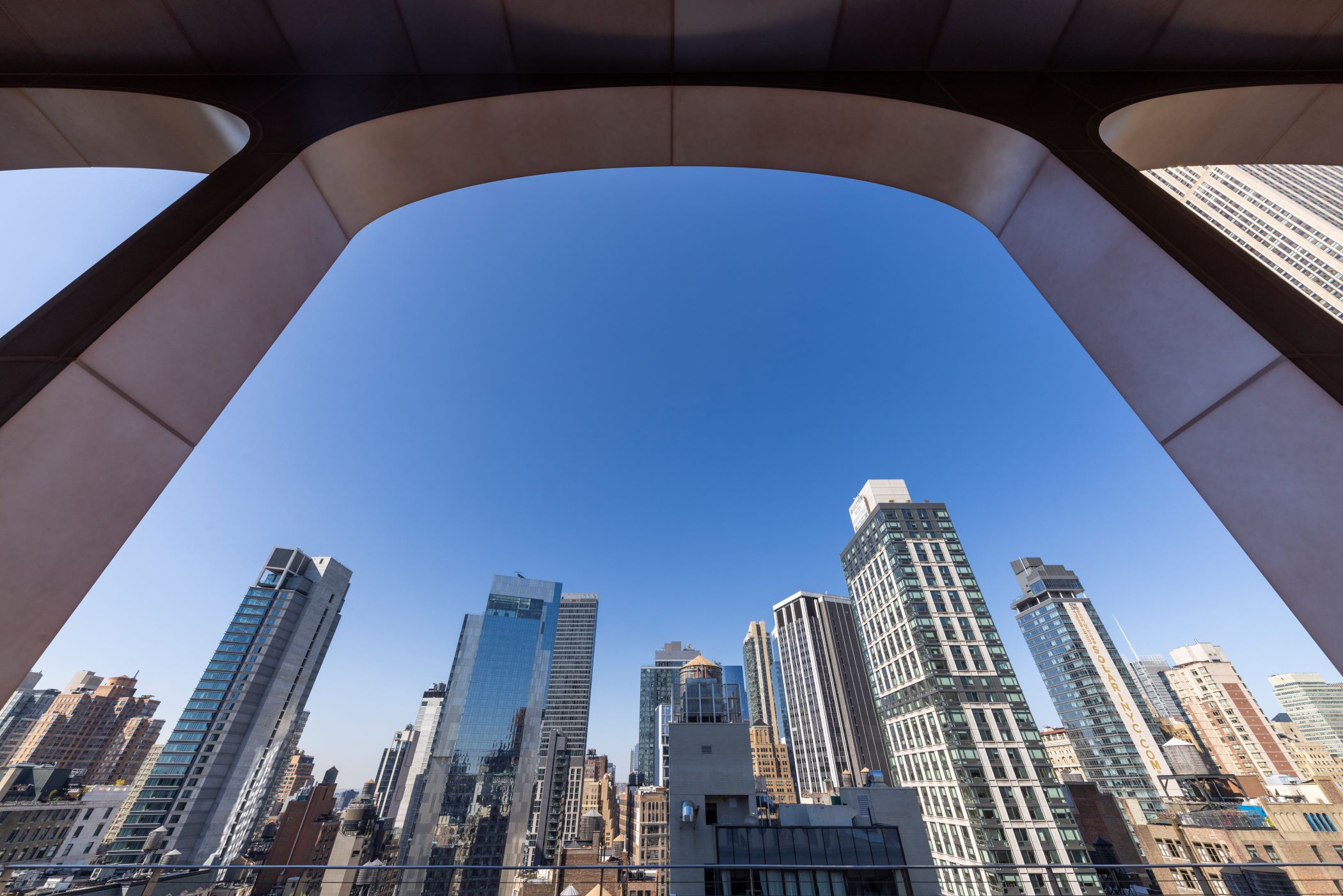 The tower at 295 Fifth Ave. in Manhattan got a two-story, 34,000-square-foot penthouse addition with an arched metal panel system that pays tribute to the building’s original arched windows. (TIG, PGIM, Meadow Partners) 