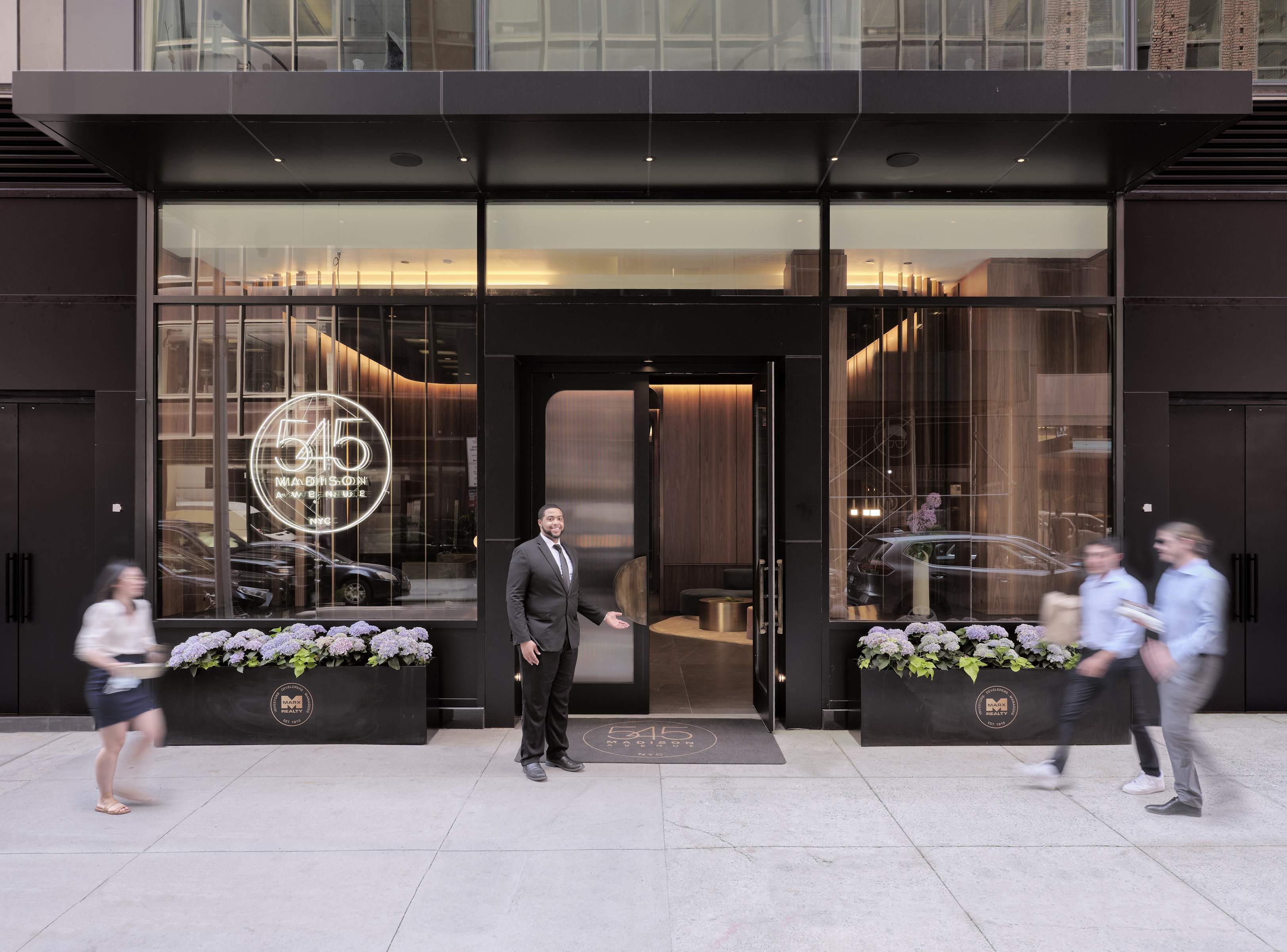 545 Madison Ave.’s overhaul includes a redesigned lobby with a uniformed doorman attending the entry doors to evoke the feel of a hotel. (Marx Realty) 