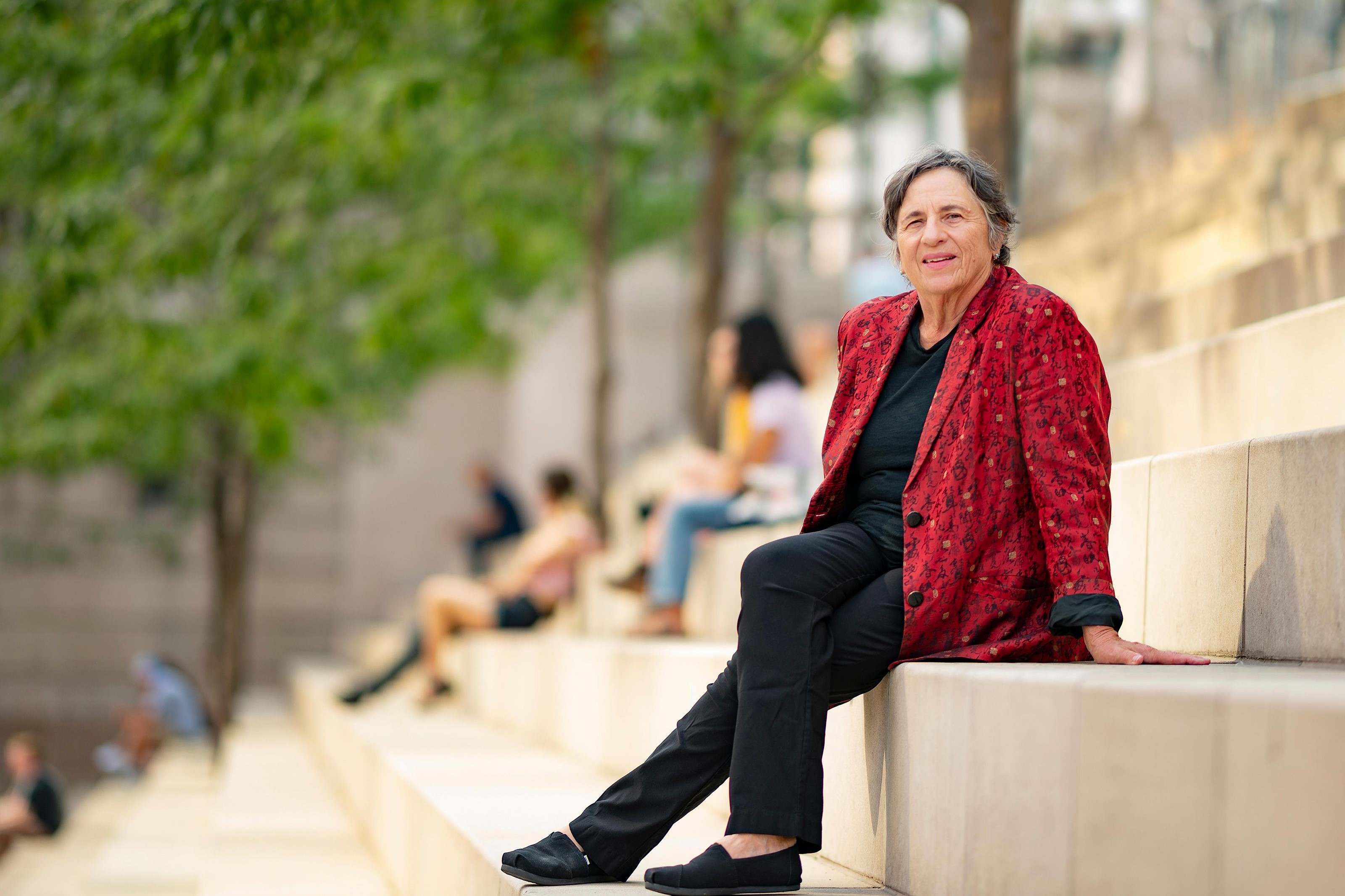 Architect Carol Ross Barney is pictured sitting on stairs of Chicago's Riverwalk, which she designed. (John Boehm)