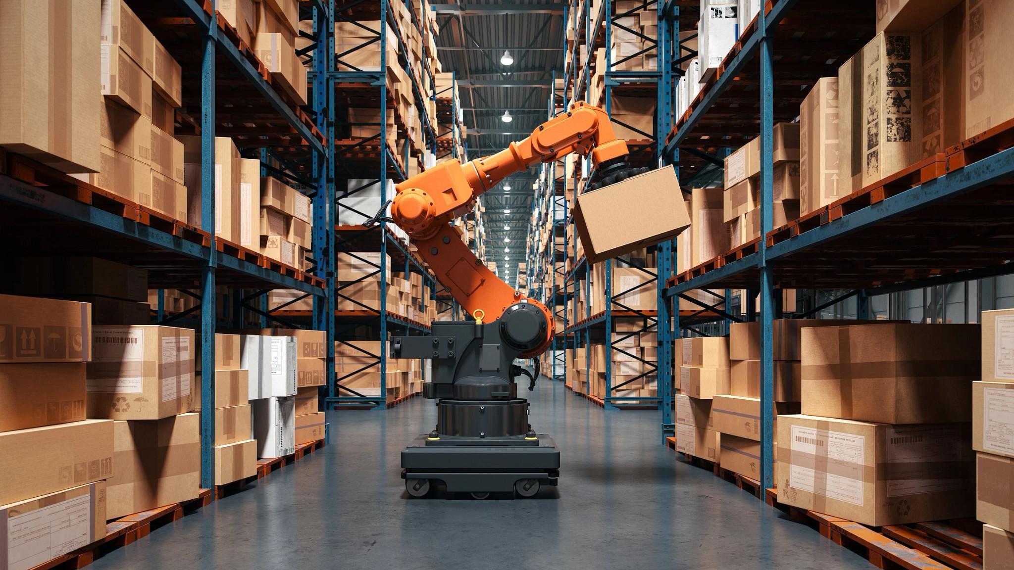 A high-tech warehouse featuring a robotic arm handling and organizing packages on industrial shelves. (Getty Images)