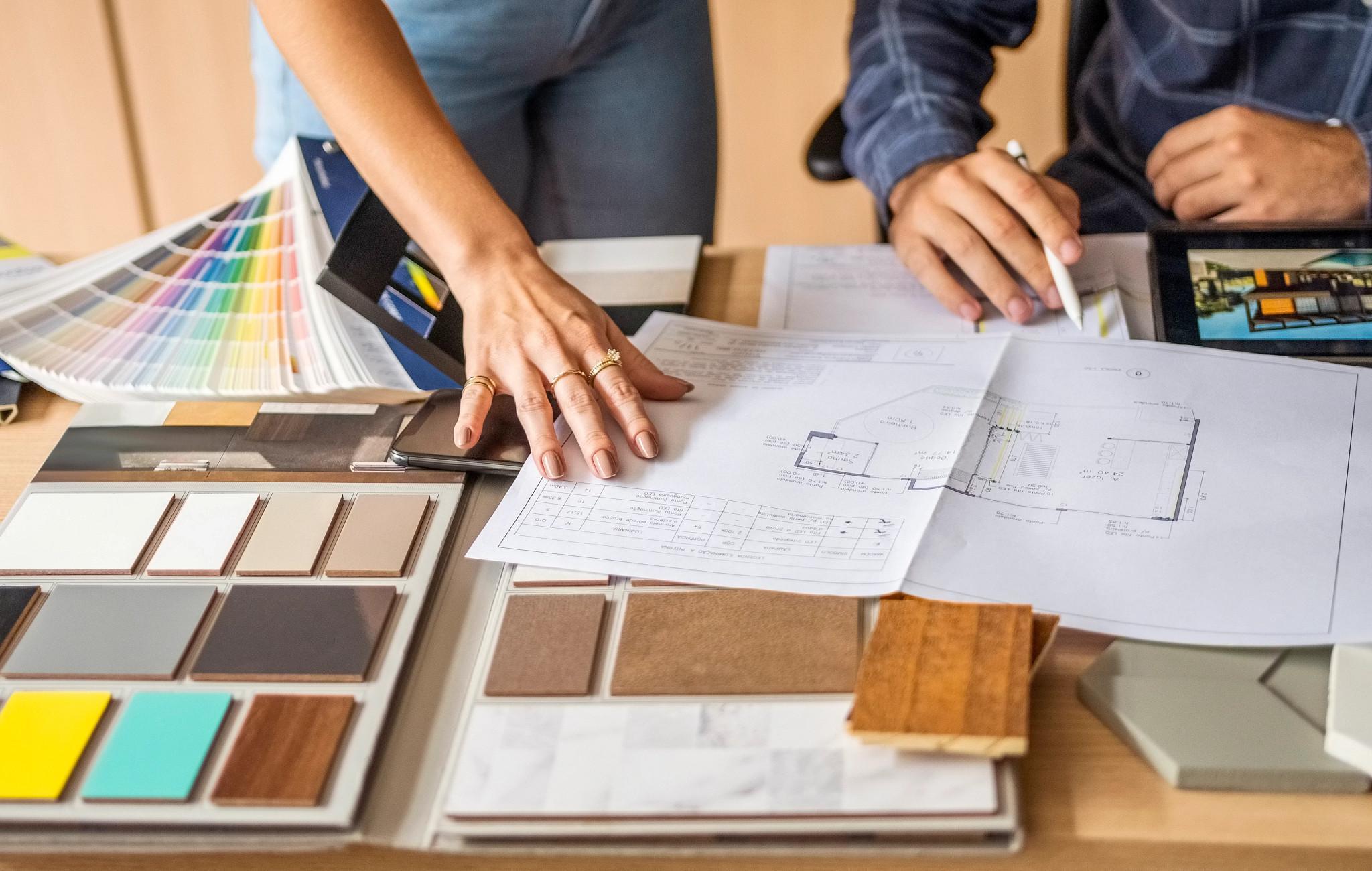 Cropped shot of a male architect discussing building blueprints with female colleague during meeting in office (Getty Images)