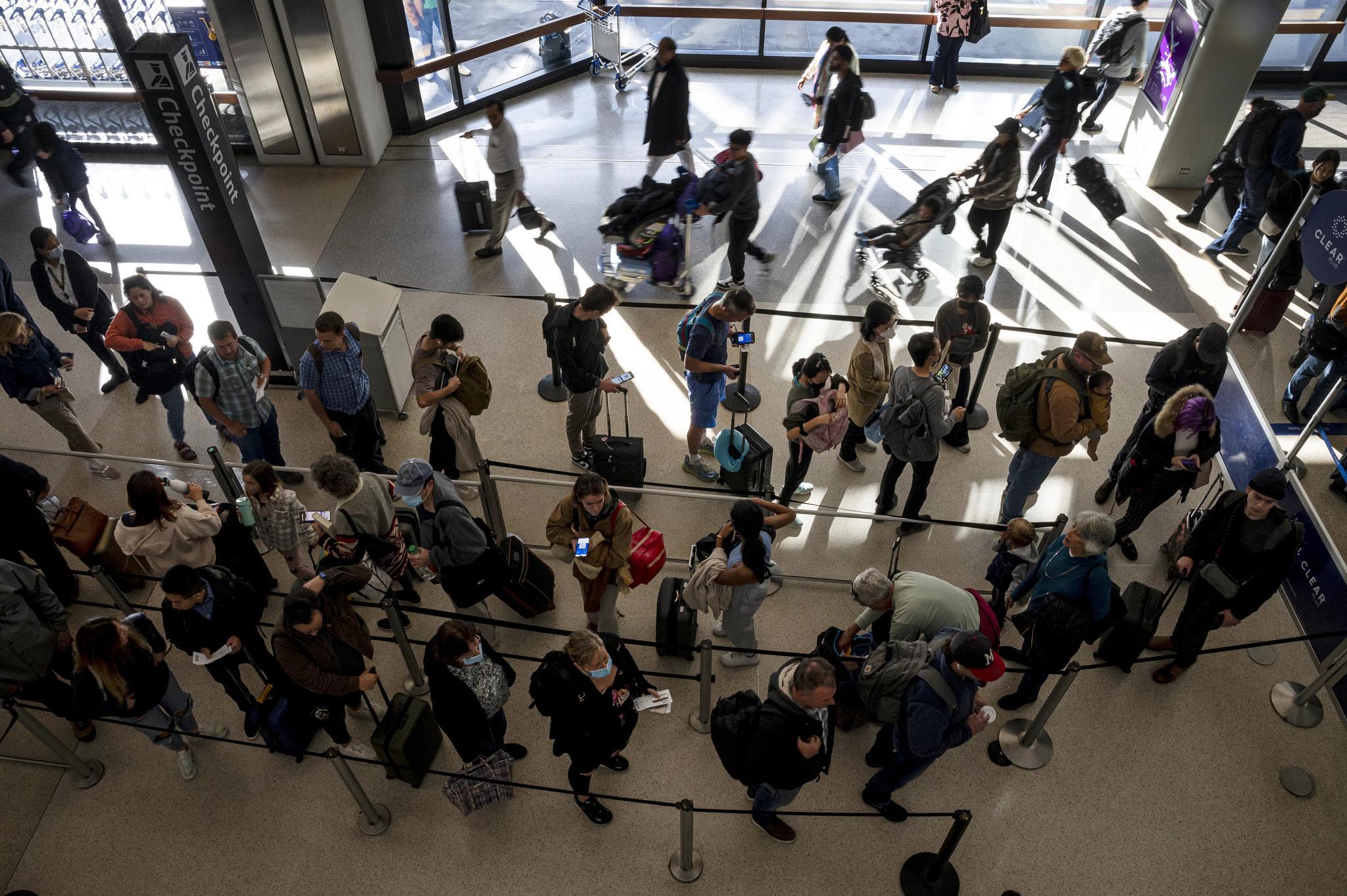 Travelers at San Francisco International Airport (SFO) in San Francisco, California, US, on Wednesday, Nov. 22, 2023. As many as 4.7 million people are expected to fly during the Thanksgiving holiday, up 6.6% from 2022 and the highest since 2005, AAA said. Photographer: David Paul Morris/Bloomberg via Getty Images (Bloomberg via Getty Images)