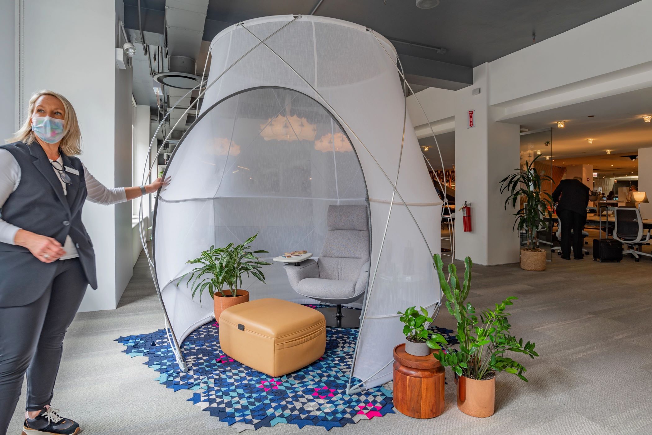 Carey Potter of Steelcase explains the company’s pod tent, one of several tents designed for the office. (Justin Schmidt/CoStar)