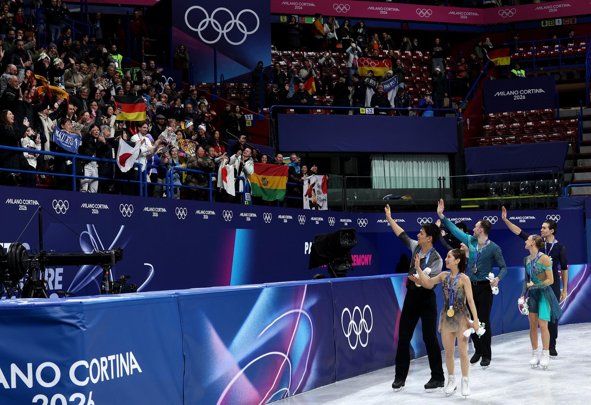 MILAN, ITALY - FEBRUARY 16: Gold medalists Riku Miura and partner Ryuichi Kihara of Team Japan, Silver medalists Anastasiia Metelkina and partner Luka Berulava of Team Georgia, and Bronze medalists Minerva Fabienne Hase and partner Nikita Volodin of Team Germany interact with the crowd after the medal ceremony for Pair Skating - Free Skating on day ten of the Milano Cortina 2026 Winter Olympic games at Milano Ice Skating Arena on February 16, 2026 in Milan, Italy. (Photo by Jamie Squire/Getty Images) (Getty Images)