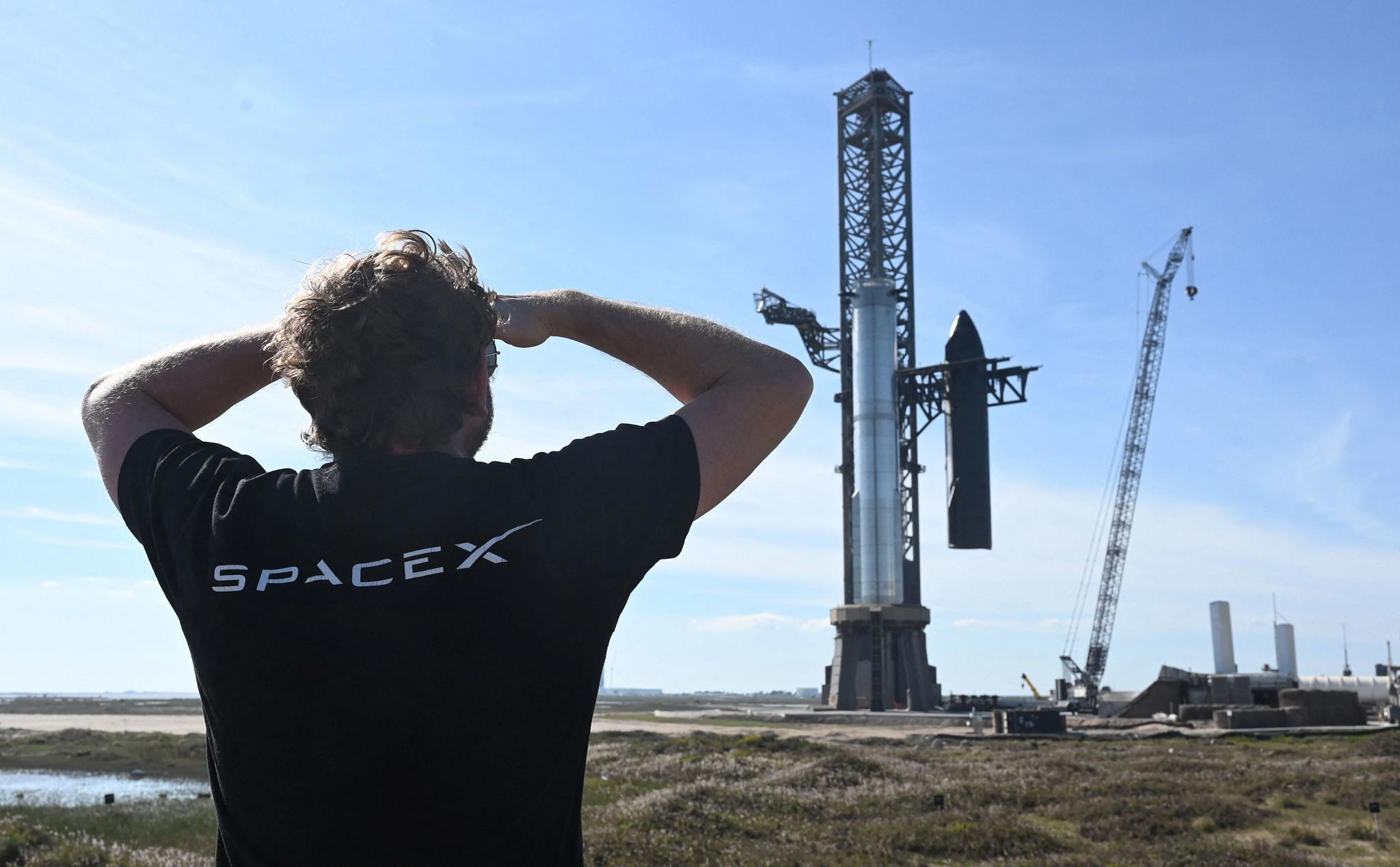 TOPSHOT - A person looks on as SpaceX's huge Super Heavy-Starship is unstacked from the booster as it sits on the launchpad at Starbase in Boca Chica, Texas, on November 16, 2023, ahead of its second test flight posponed to November 18. The US Federal Aviation Administration (FAA) on November 15, 2023 authorized SpaceX to carry out its second launch of Starship, the most powerful rocket ever built, after a first attempt in April ended in a spectacular explosion. (Photo by TIMOTHY A. CLARY / AFP) (Photo by TIMOTHY A. CLARY/AFP via Getty Images) (AFP via Getty Images)