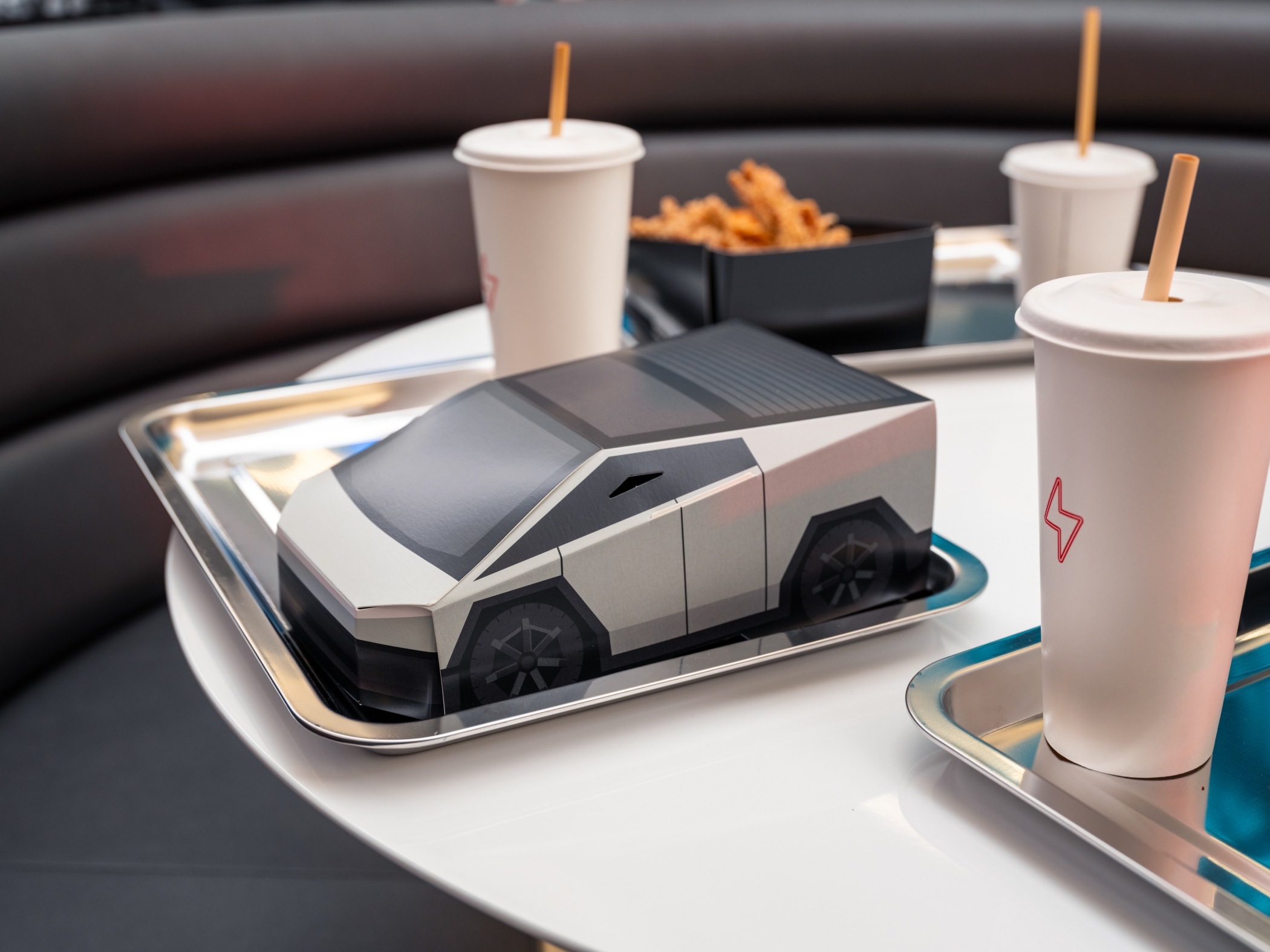 Comfort food classics like burgers, wings and milkshakes are served in Cybertruck-shaped boxes, with orders placed via car touchscreen or robot kiosk. (Tesla)