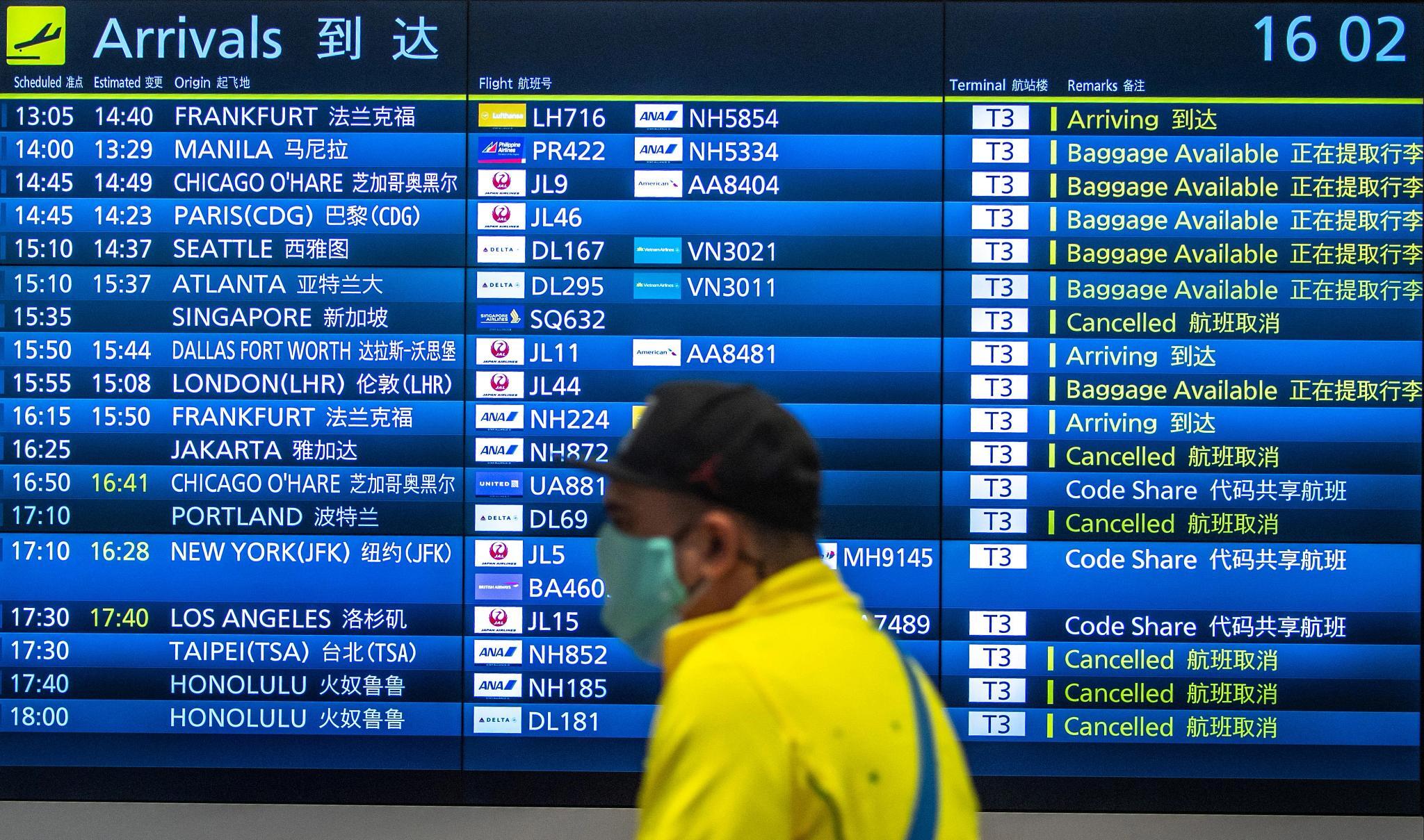 A passenger walks past a board showing international flight arrivals at Tokyo's Haneda Airport. U.S. hotels benefited from increased tourism from Japan in 2022, despite COVID-19 restrictions. (Getty Images)