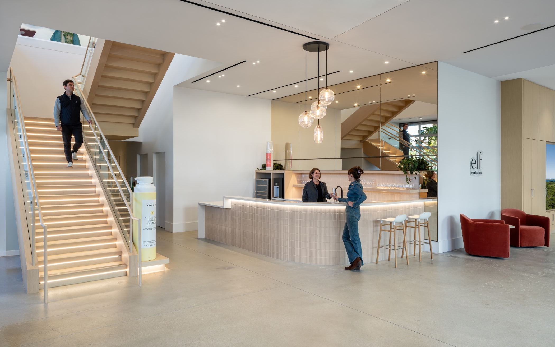 A light-filled lobby centers on a café counter with a floating staircase and polished concrete floors designed to host upscale events. (Hunter Kerhart Photography)