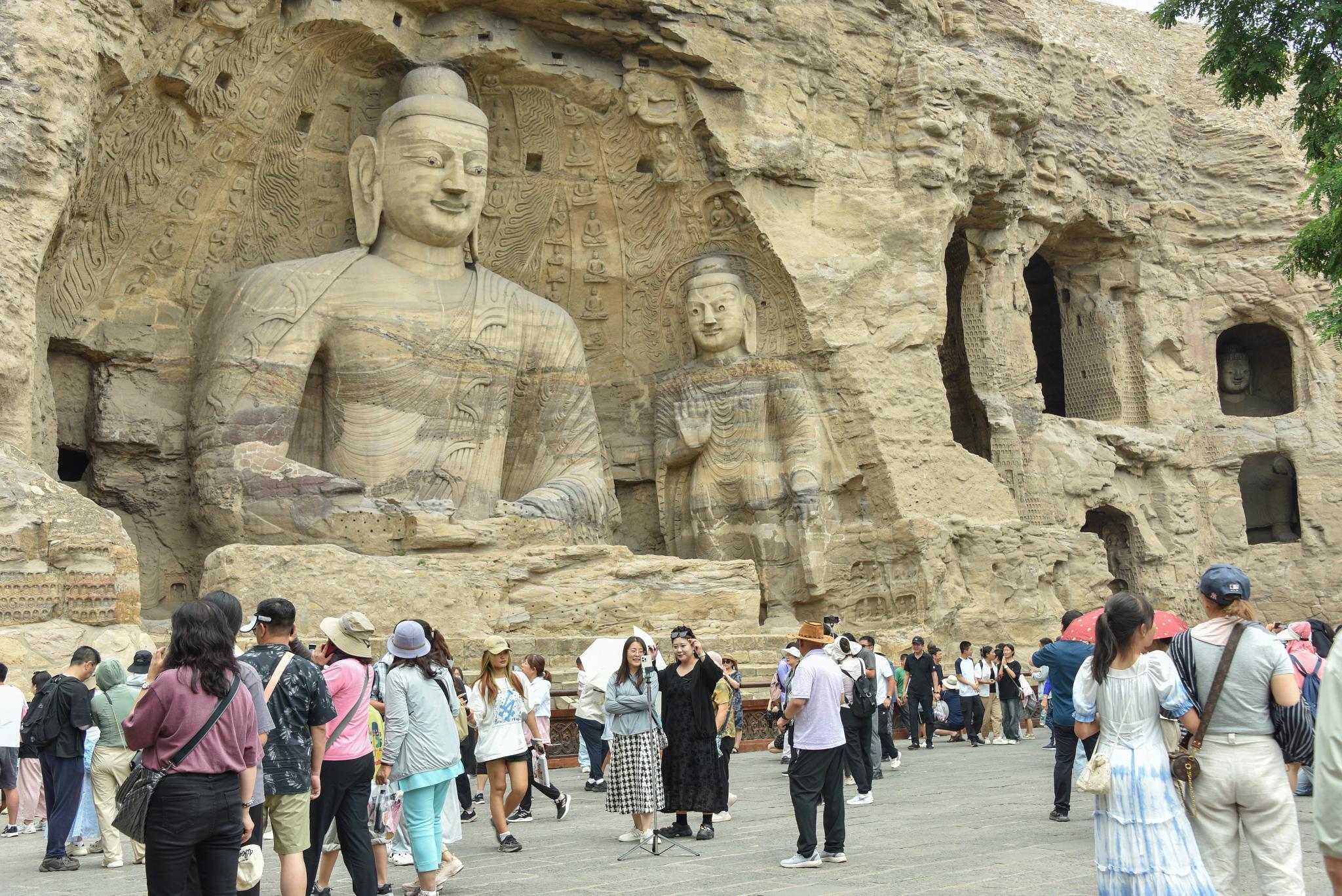 Tourists browse the Yungang Grottoes, a famous World cultural Heritage site, in Datong, North China's Shanxi Province on July 8. (Getty Images)